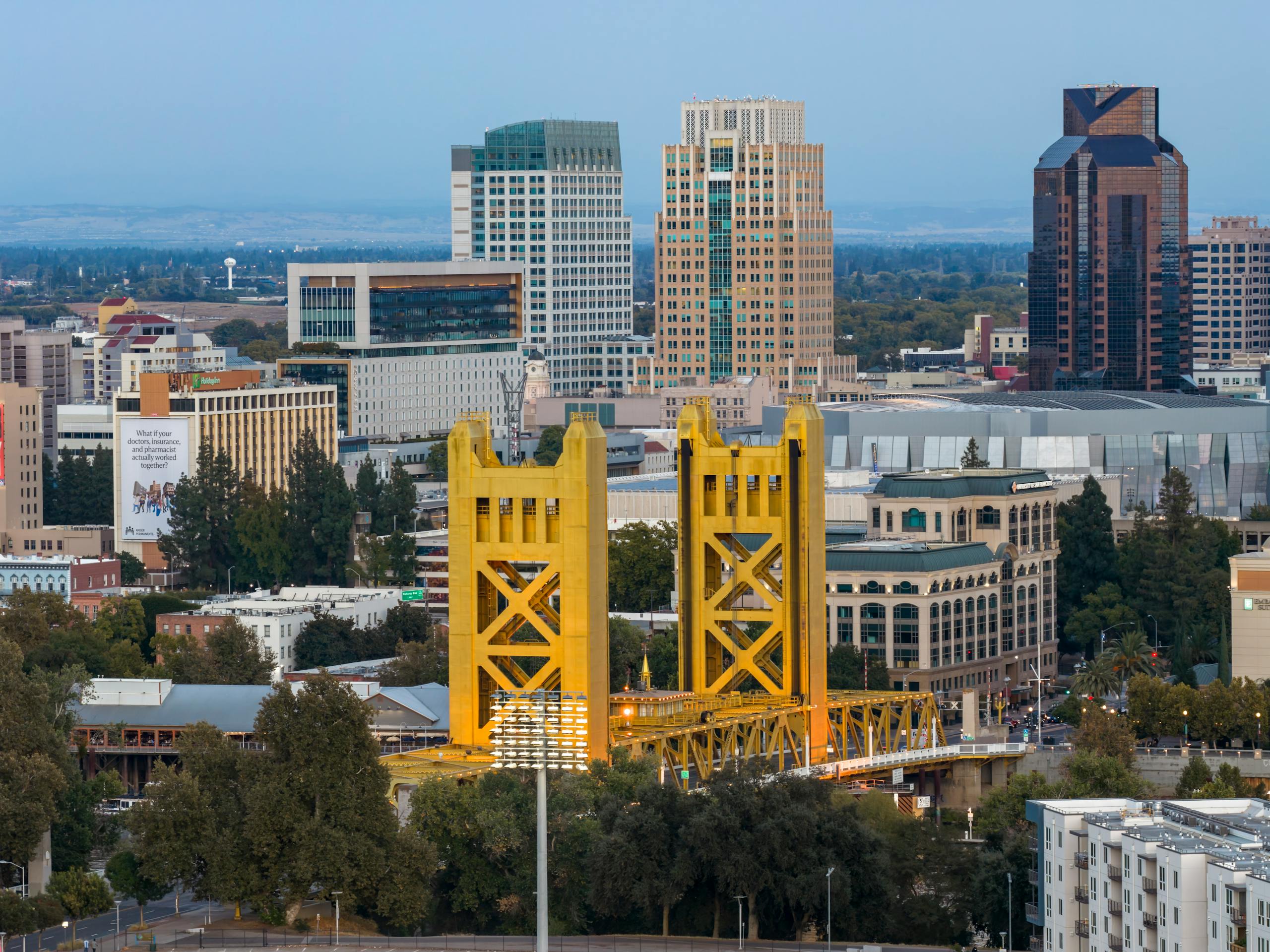 Dramatic aerial view capturing the iconic Tower Bridge and the striking skyline of Sacramento, California at day.