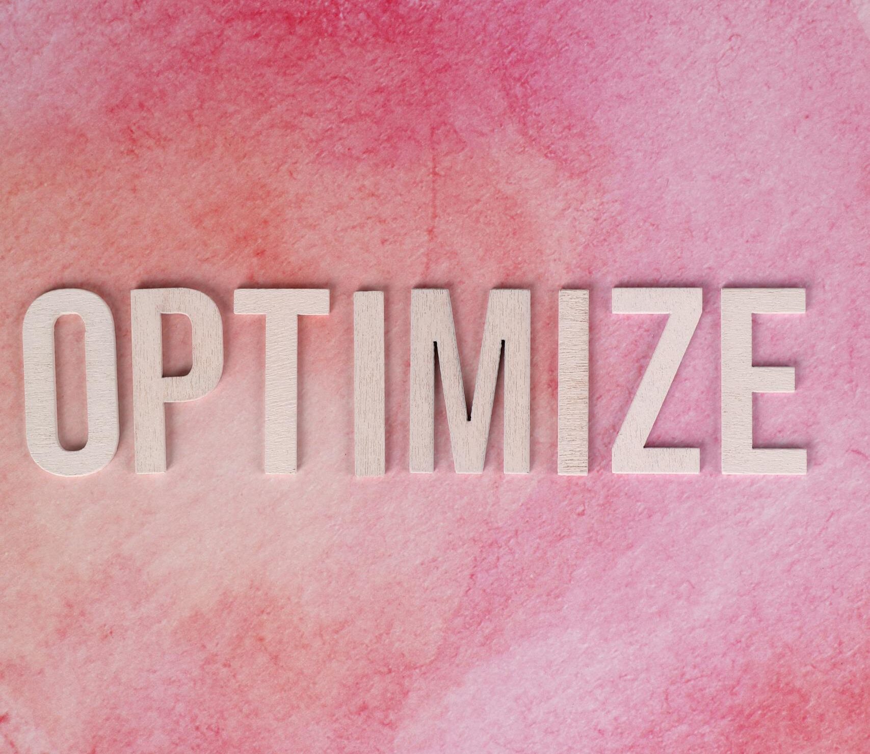 Inspirational 'Optimize' text on a pink watercolor background for creative projects.