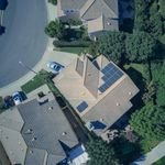 Solar performance inspection. An aerial view showcasing modern suburban houses equipped with solar panels for renewable energy.