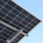 A modern solar panel with a clear blue sky background, highlighting renewable energy.